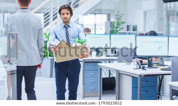 Sad Fired / Let Go Office Worker Packs His\
Belongings into Cardboard Box and Leaves Office. Workforce\
Reduction, Downsizing, Reorganization, Restructuring, Outsourcing.\
Mass Unemployment Market\
Crisis