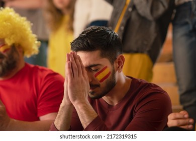 Sad Football Fan Sitting At Football Stadium, Spanish National Team In Live Soccer Match.