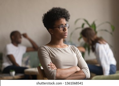 Sad frustrated mixed race girl loser feeling jealous offended sitting alone in cafe after fight with friends being rejected, upset african american student outcast bully victim suffer from jealousy