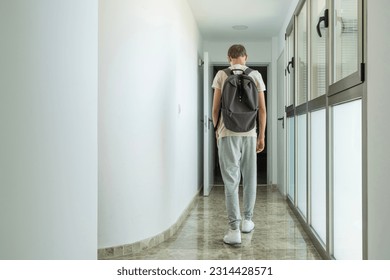Sad frustrated teenage boy walks away down school corridor alone. Education difficulties, problem with family, emotion, anxiety, depression in adolescence concept - Powered by Shutterstock