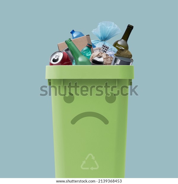 Sad garbage can character full of\
undifferentiated waste, improper waste disposal\
concept