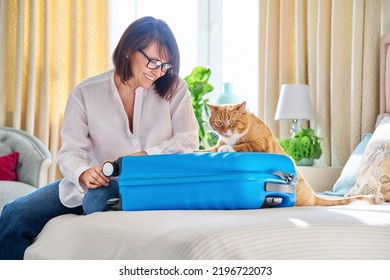 Sad Ginger Cat Lying On Suitcase Of Owner Middle-aged Woman