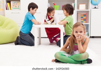 Sad Girl Feeling Excluded From The Group Of Playing Kids