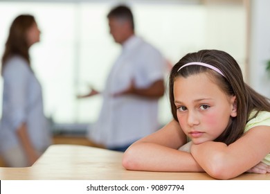 Sad girl with her fighting parents behind her - Powered by Shutterstock