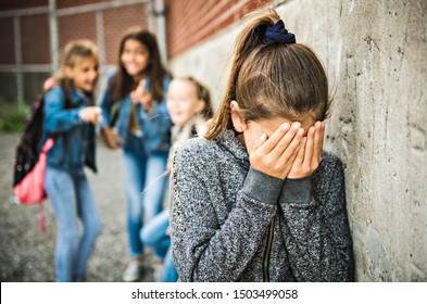 A sad girl intimidation moment on the elementary Age Bullying in Schoolyard - Shutterstock ID 1503499058