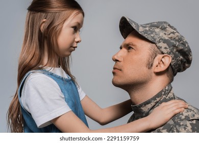 sad girl looking at serviceman in military uniform crying during memorial day isolated on grey - Powered by Shutterstock