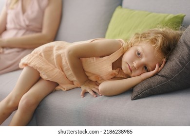 Sad Girl Lying On The Couch Next To Her Mother, Childhood Trauma And Emotional Disorder Concept