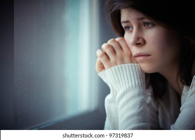 sad girl near window thinking about something