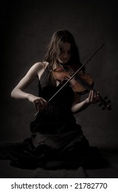 Sad Girl Play On Violin In Dark Room