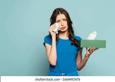 Sad Girl Wiping Tears With Paper Napkin While Crying Isolated On Blue