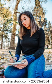 Sad Girl Writing A Letter In A Park