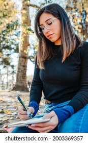 Sad Girl Writing A Letter In A Park