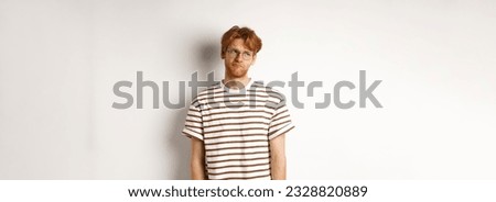 Sad and gloomy redhead man looking upper left corner, sulking and feeling like loser, standing over white background.