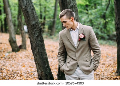 Sad Groom In Beige Tuxedo Is Standing Near The Tree. Autumn Wedding. Soft Focus