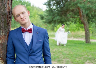 Sad Groom Of European Appearance And The Bride Blurred In The Background.