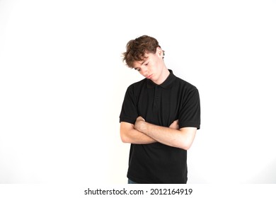 Sad guy looking down with his arms crossed portrait, white background, 18-20 years old. White european guy.