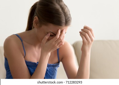 Sad heartbroken young woman holding wedding ring, upset abandoned wife crying about ruined bad marriage engagement, cheated lovelorn girl in tears depressed after breaking up or getting divorced