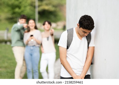 Sad Hispanic Teenager Boy Against Wall Suffering Bullying.