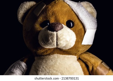 sad injured teddy bear in need of medical care. Conceptual image about violence or child abuse