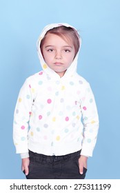 Sad Kid Girl 3-4 Year Old Wearing Sporty Hoodie Over Blue. Childhood. Looking At Camera.