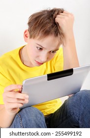 Sad Kid With Tablet Computer On The White Background