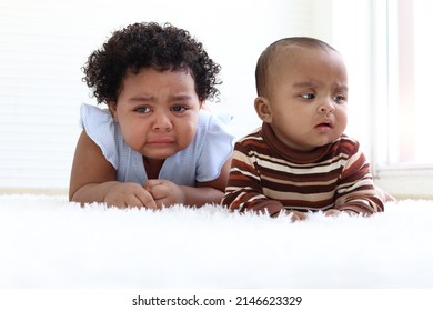 Sad little African American girl with curly hair and baby sister crying, drop of tear running down cheek, eye discharge, kid getting upset and bad-tempered.