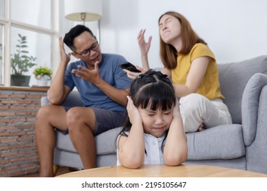 Sad Little Asian Girl Close Her Ears While Her Parent are Having a Fight in the Livingroom For Domestic Violence Concept - Powered by Shutterstock
