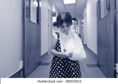 Sad Little Girl With A Broken Arm In Hospital Corridor.(BW) Concept Photo Of Children Health And Medical Care