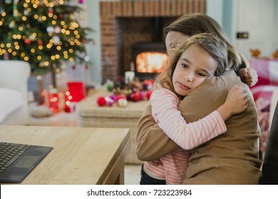 Sad Little Girl Is Cuddling With Her Mother At Christmas Time.