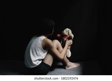 Sad little girl sitting in dark room. human trafficking concept. - Shutterstock ID 1802192476