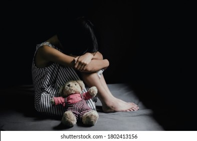 Sad Little Girl Sitting In Dark Room. 