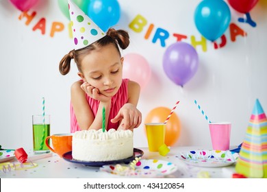 Sad little girl sitting at the holiday table - Powered by Shutterstock