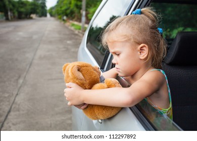 Sad Little Girl Sitting Near The Window In The Car