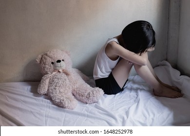 Sad Little Girl Sitting In Room. Human Trafficking Concept.