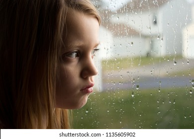 Sad Little Girl Staring Out Rainy Window