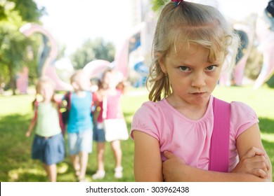 Sad lonely child being bullied by children