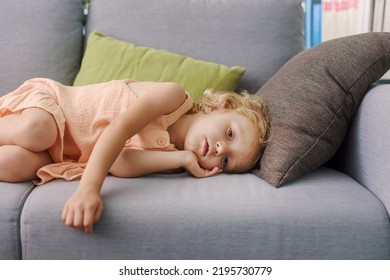 Sad Lonely Child Lying On The Couch At Home, Emotional Distress And Childhood Trauma Concept