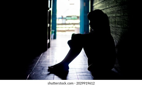 Sad Lonely Little Girl Crying While Sitting On The Floor In  Dark Room With An Attitude Of Sadness.Concept Of Depression Or Domestic Violence Child