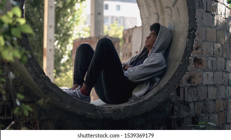 Sad lonely student in hoodie sitting alone abandoned building, puberty isolation - Shutterstock ID 1539369179