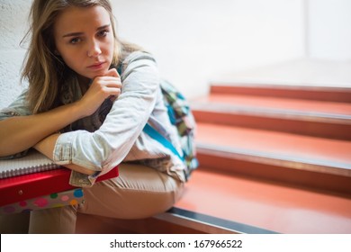 Sad Lonely Student Sitting On Stairs Looking At Camera In College