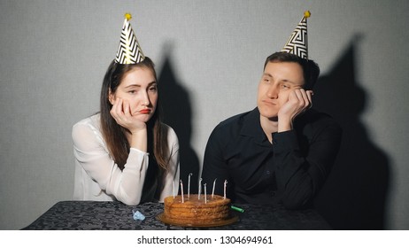 Sad Lonely Woman And Man In Party Hat Celebrating Birthday Alone.