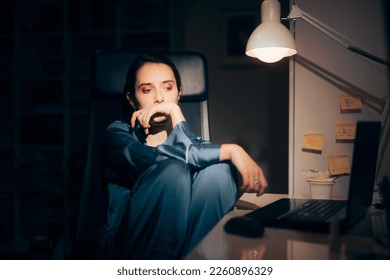 
Sad Lonely Woman Sitting at Home Working at Night. Unhappy person checking for symptoms online unable to sleep
