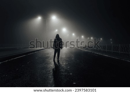 Sad man alone walking along the alley in night foggy road