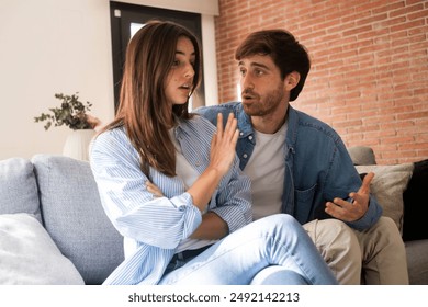 Sad man asking sorry to upset woman both sitting on the sofa at home. Discussion between man and woman about jealousy and relationship problems. Breakup marriage divorce concept. Guilty husband cheat - Powered by Shutterstock