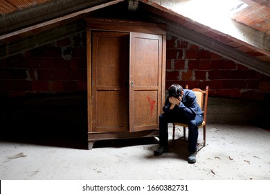 Sad Man In The Attic And An Old Wooden Wardrobe