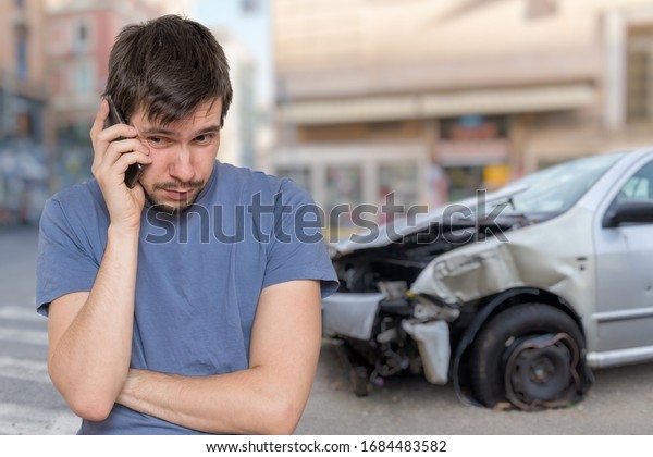 Sad man\
is calling to assistance after car\
accident.