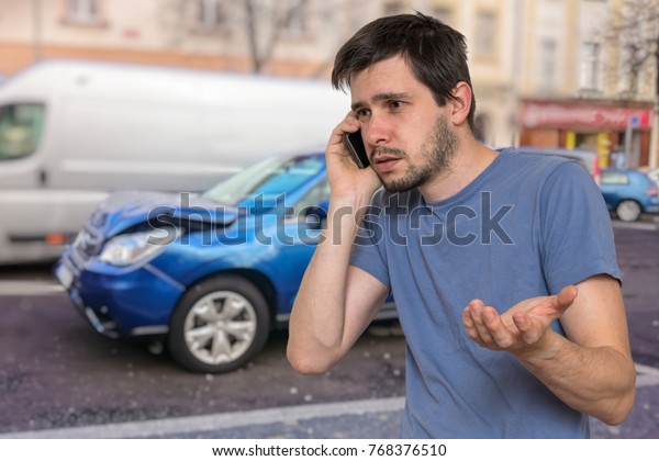 Sad man\
is calling to assistance after car\
accident.