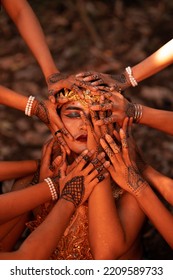 Sad Man Faces Covered Up By A Lot Of Hands With Henna Tattoos While Wearing A Gold Crown On Her Head