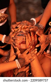 Sad Man Faces Covered Up By A Lot Of Hands With Henna Tattoos While Wearing A Gold Crown On Her Head