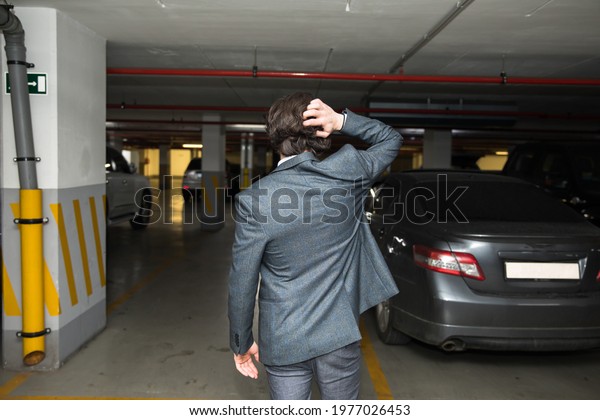 sad man with\
find car at underground\
parking\

